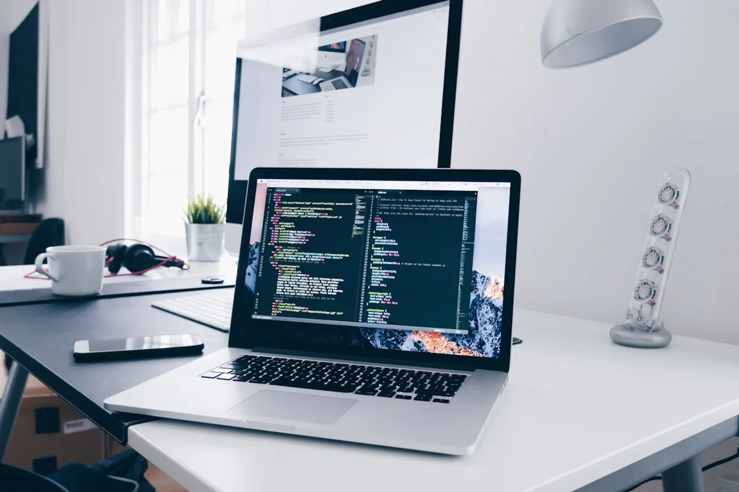 Developer workspace with laptop showing code.